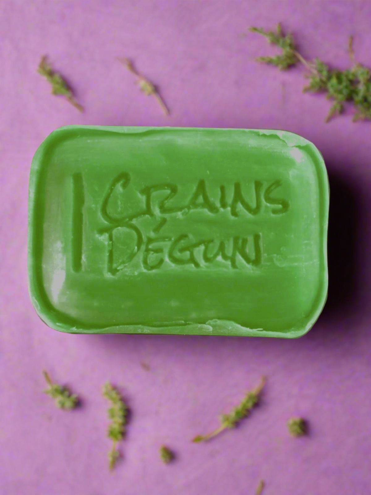 Green bar soap with crains degun engraved in the middle of the soap on a purple background